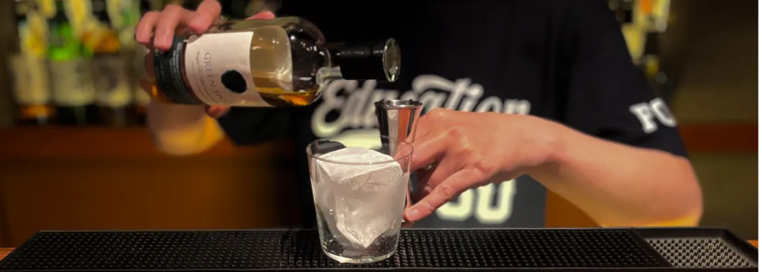 グラスにウイスキーを注ぐ様子